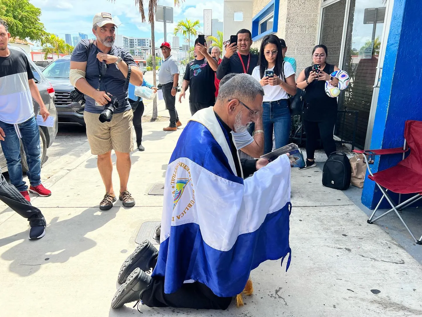 Padre José Palmar arrodillado en oración durante una vigilia en la calle
