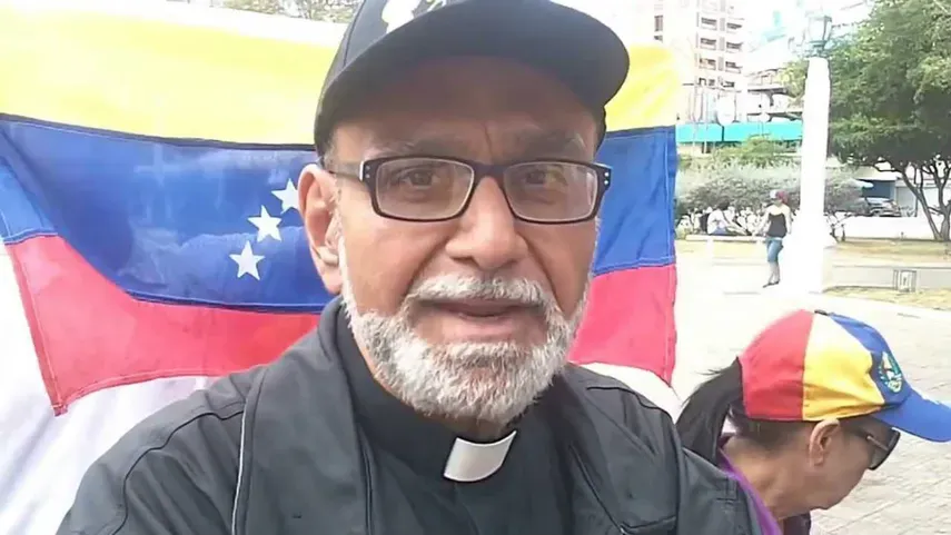 Padre José Palmar con la bandera de Venezuela de fondo